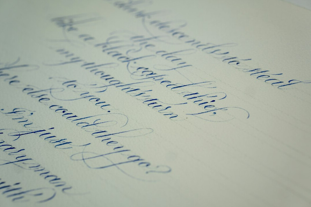 Open notebook with handwritten notes and a pen on a wooden desk